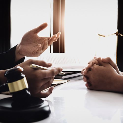 image of two people talking at a desk that has a gavel on it